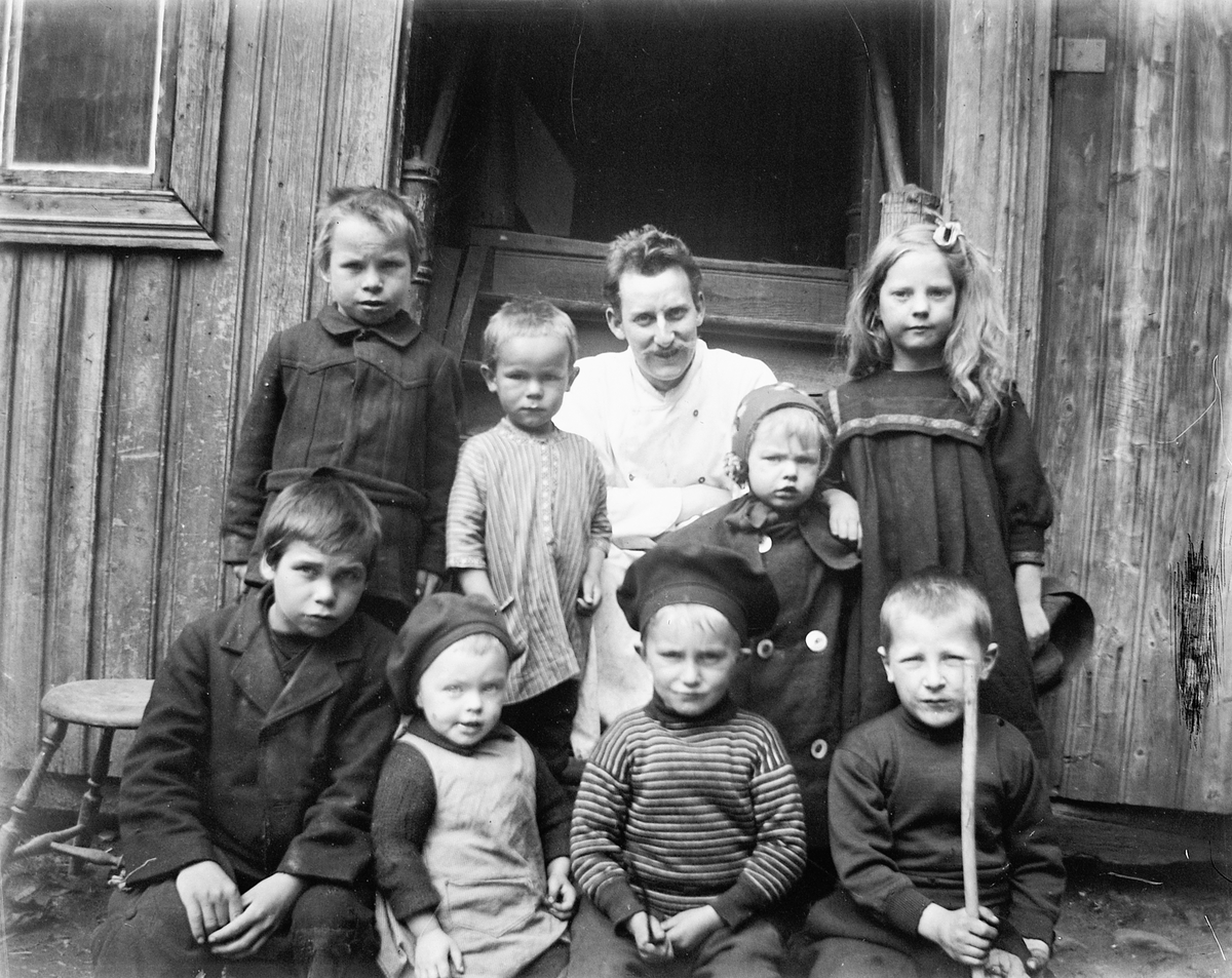 Johs. (Johannes) Johannessen, Ukjent mann sammen med åtte barn på en trapp.