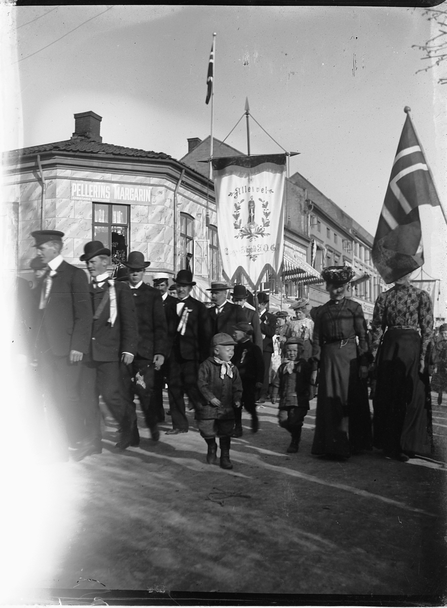 Johs. (Johannes) Johannessen, 1. mai-tog i 1910 utenfor Strandgata 15 i Hamar. Fane med skriften Alles vel som tilhørte loge "Skjold".