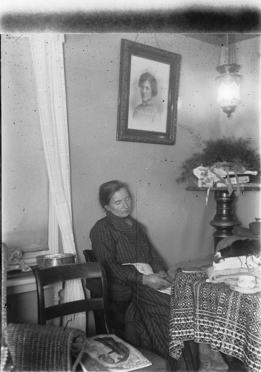 Ragnvald Andersen, Kvinne sitter i en stol og sover lent mot veggen. Interiør.