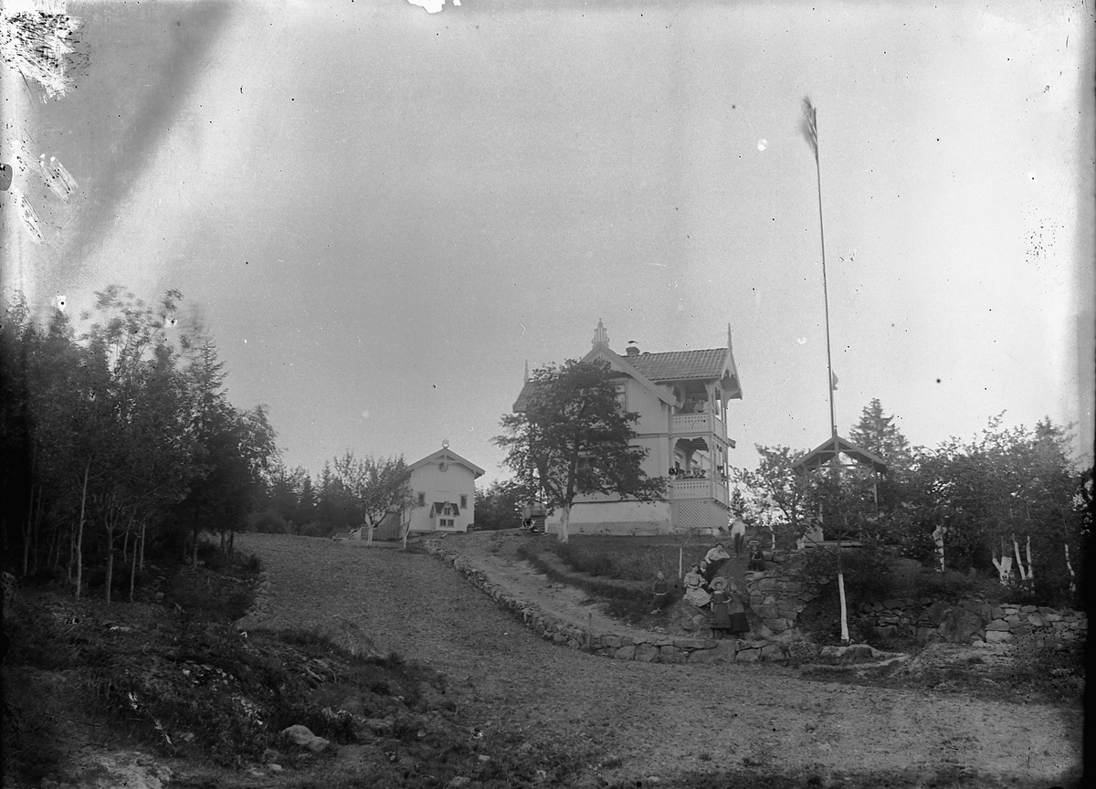 Ragnvald Andersen, Gruppe mennesker ved et hus med flaggstang med det norske flagget. Harder? Stavgården?