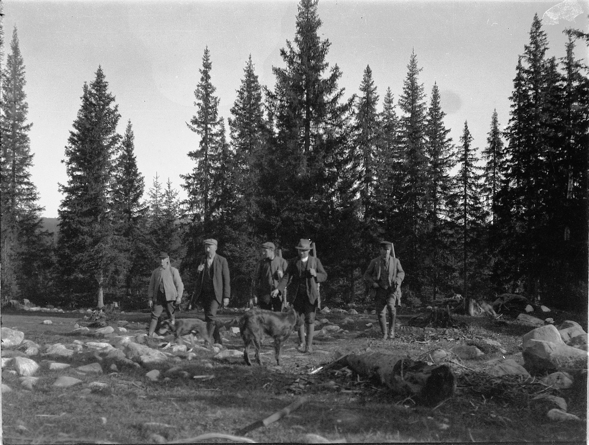 Ragnvald Andersen, Fem menn på jakt i skogen med våpen og hunder.