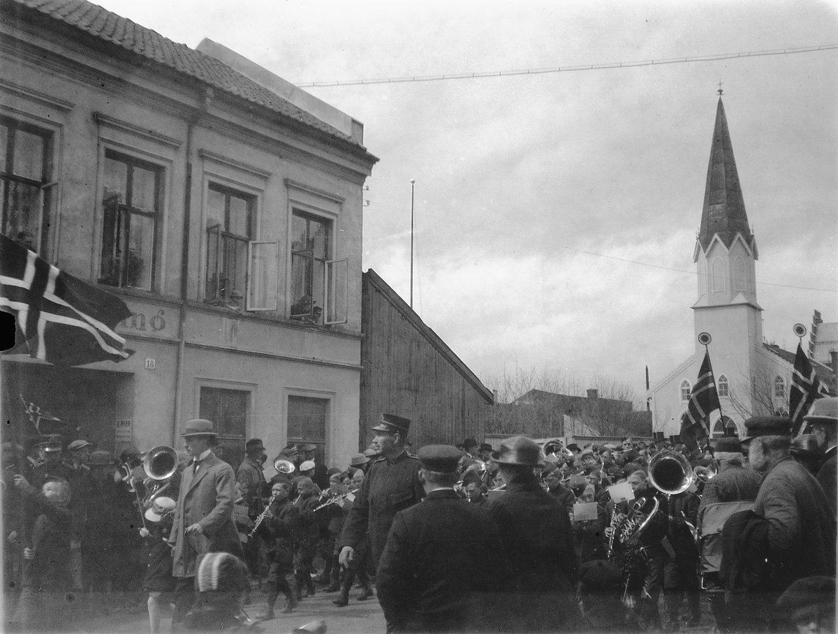 Ragnvald Andersen, 17. mai tog i Grønnegata, Hamar. Korps spiller i gata. Metodistkirken i bakgrunnen.