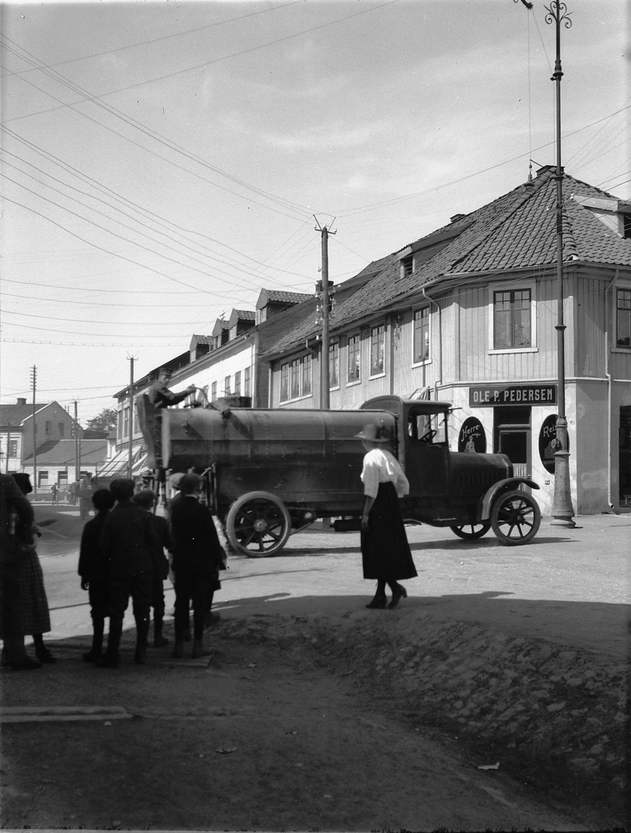 Ragnvald Andersen, Torggata, Hamar kommunes lastebil, Vomag, D-1168, 1921 modell. vanntank. Ole P. Pedersens forretning til høyre.