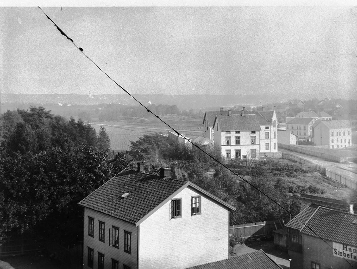 Hans Emil Erichsen, Sverresgate, Vangsvegen i Hamar. Bebyggelse. Wiberg, Erkegården t. h. Bygningen midt på bildet er Høgsnesgården. I forgrunnen til høyre er "Hamar Sæbefabrik", startet i 1888 av Ole Erichsen og stadsingeniør Claussen.