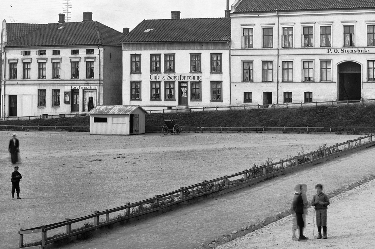 Hans Emil Erichsen, Østre Torg i Hamar med Grønnegata og Håkons Gate. Folk på torget. P.O. Stensbak Møbel Speil & Ligkisteutsalg. Cafe & Spiseforretning. Elise Tøsties Eftfl. Utsnitt.