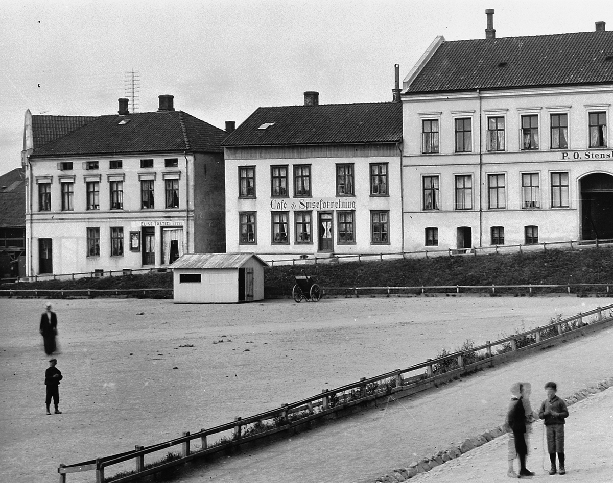 Hans Emil Erichsen, Østre Torg i Hamar. Håkons Gate. Folk på torget. Cafe og Spiseforretning. P. O. Stensbak møbel speil & ligkisteudsalg. Utsnitt.