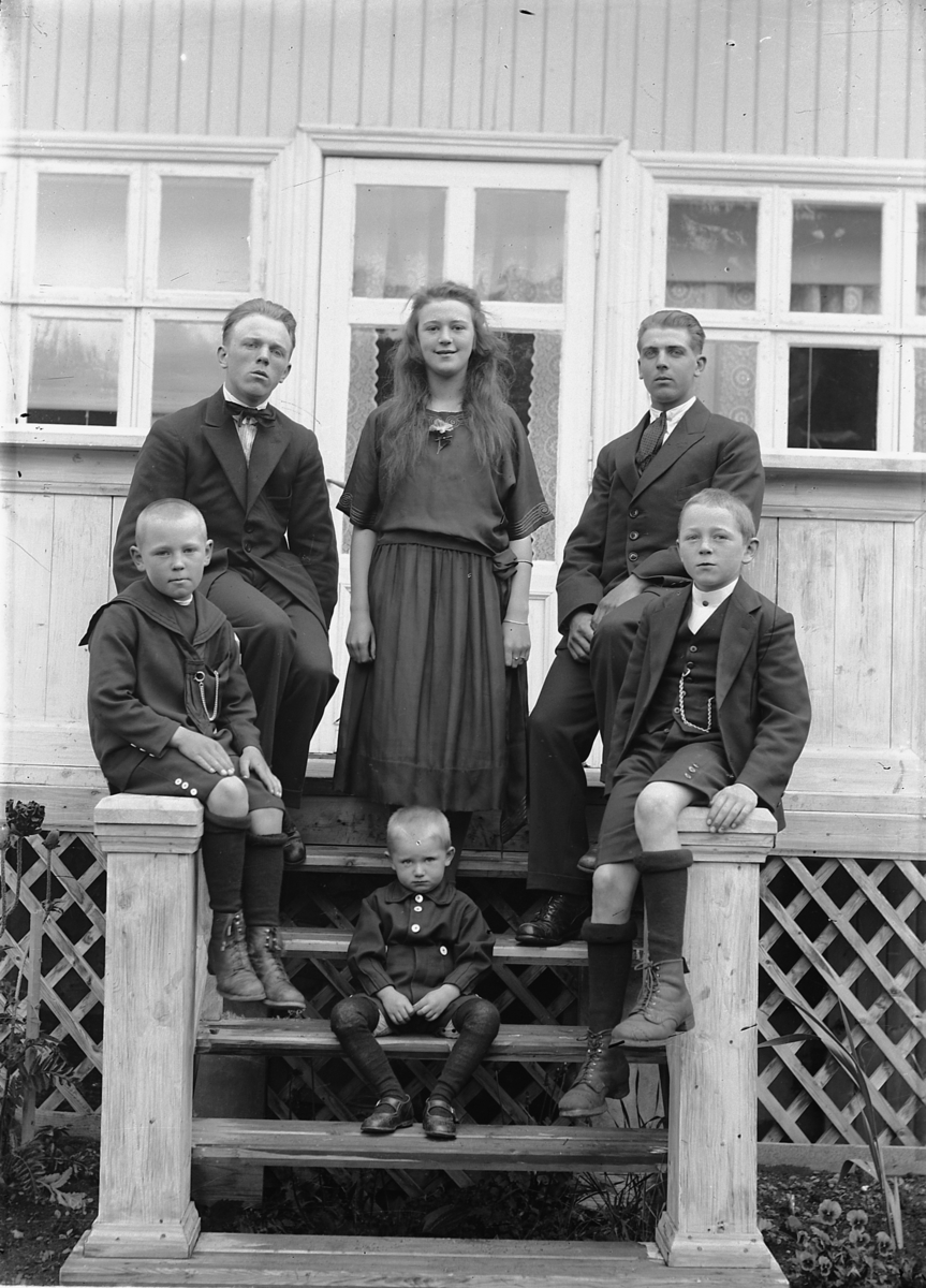 Simen Baardseth, To menn, ei kvinne og tre gutter samlet på en veranda.