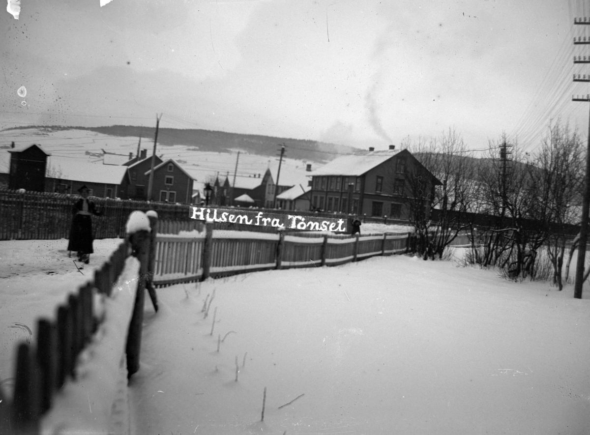 Johannes Larsen Alhaug, Tønset, Tynset. Bebyggelse. Ei kvinne på ski til venstre.
