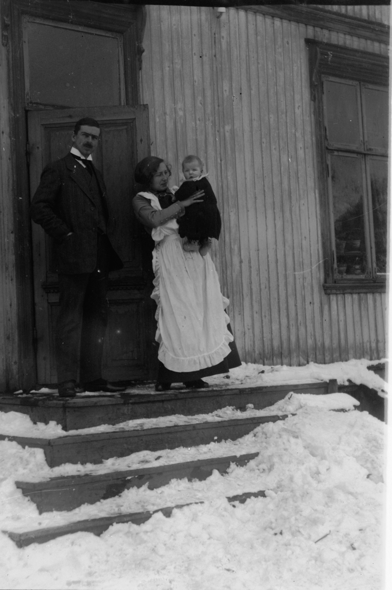 Hans Emil Erichsen, To voksne med barn på armen i trapp.