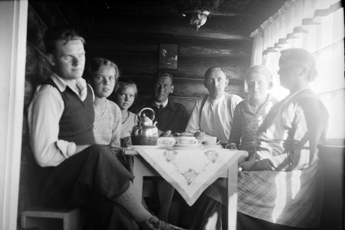 Håkon Prestkværn, Interiør, ukjent familie samlet rund bord, drikker kaffe, kakefat, måltid. Mannen i midten heter Kolbjørn Øvre.