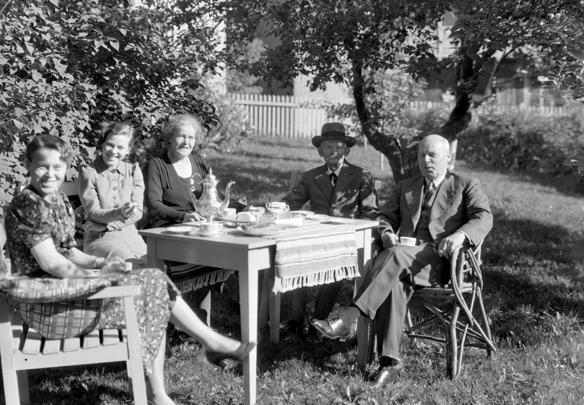 Normann Fotoatelier, Statsråd Christian Fredrik Monsen (27. 04. 1874 - 31. 01. 1954) th. Norsk politiker for AP, stortingsrepresentant fra 1922 til 1949, stortingspresident 1945 til 1948 og forsvarsminister i tre perioder. Fru Monsen sitter i midten. Familiegruppe i hagen.