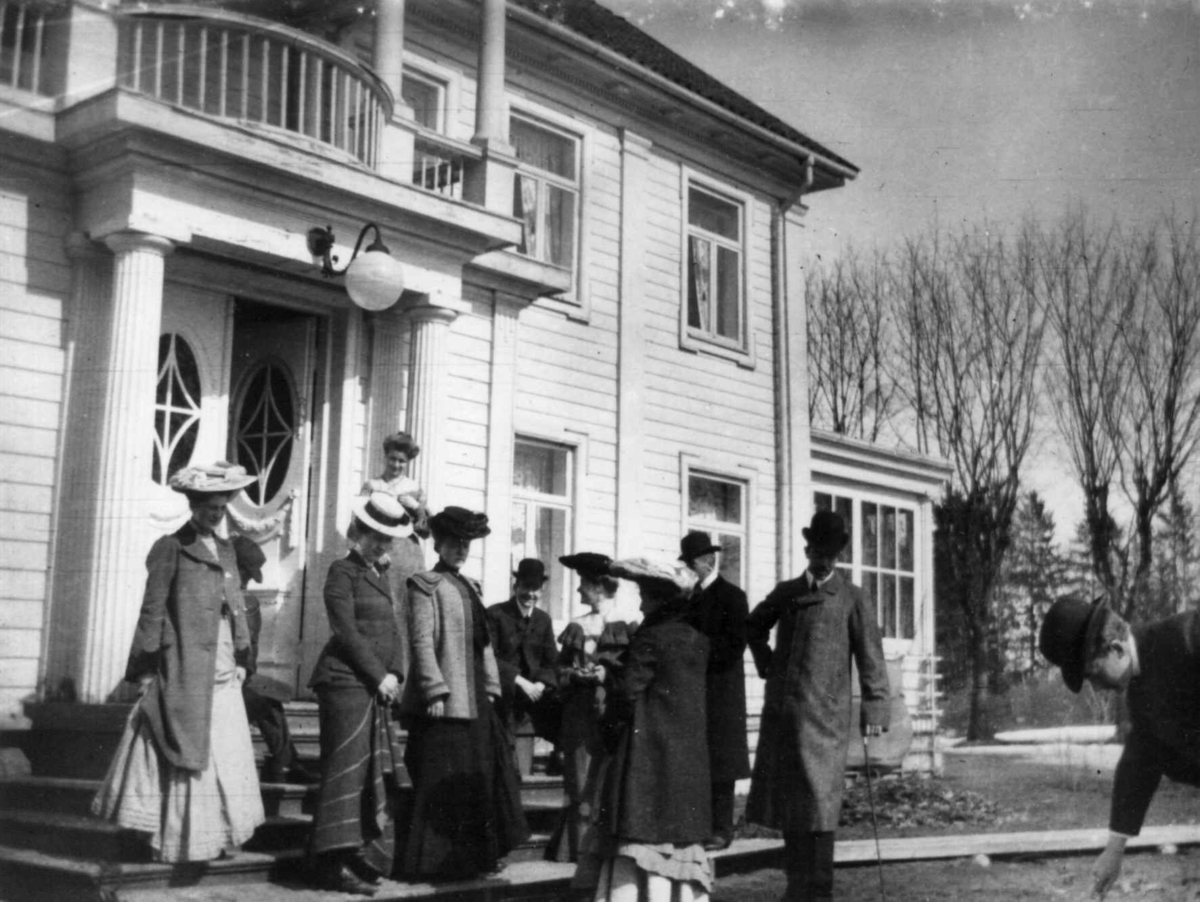 Fredrik Emil Faye, Gruppeportrett, Eidsvold Verk, Eidsvoll. Personer ved inngangsparti med søyler. Ant. 1904. Fra serie antatt fotografert av kammerherre Fredrik Emil Faye (1844-1903), Dal gård, Ullensaker.