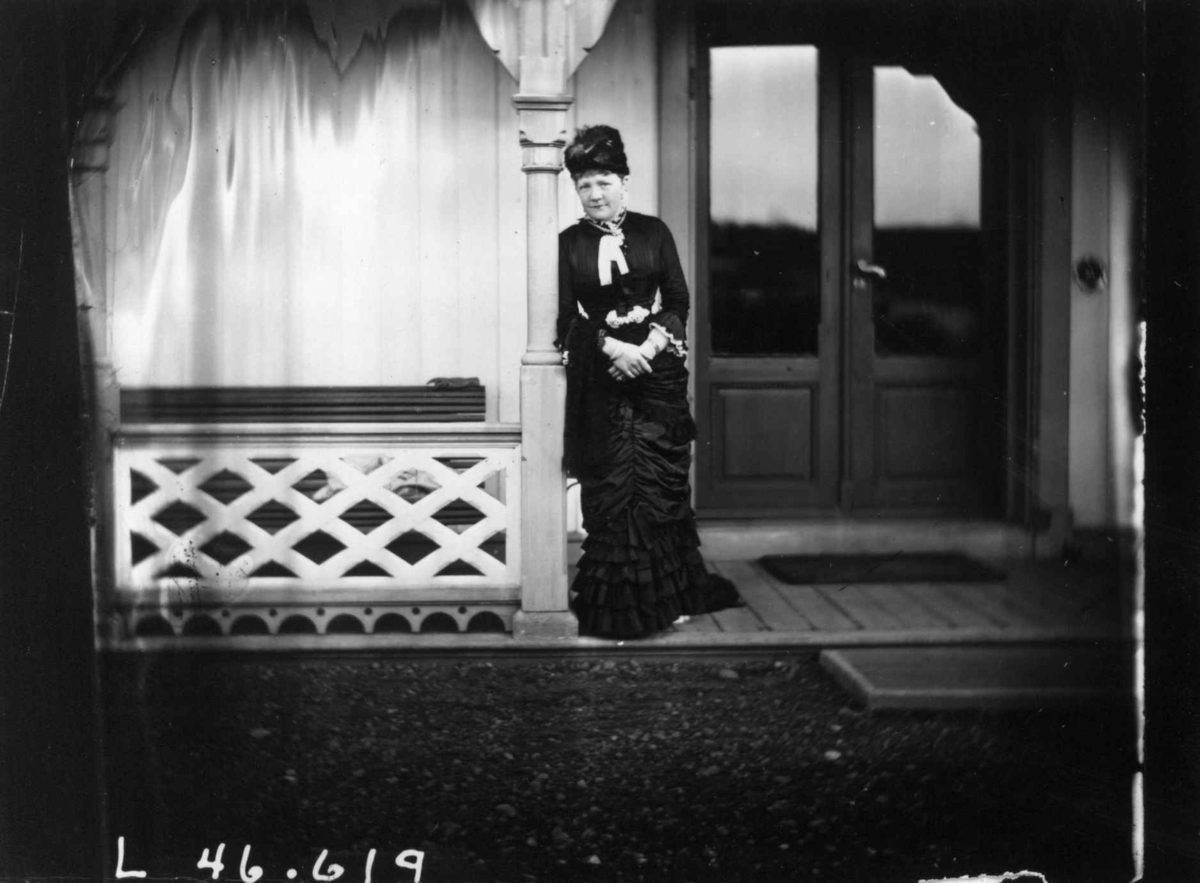 Fredrik Emil Faye, Portrett, Hagar Parr, ca. 1882, stående ved inngangsparti. Fra portrettserie av personer som bodde på eller besøkte Dal gård, Ullensaker, fotografert av gårdens eier, kammerherre Fredrik Emil Faye (1844-1903) i årene 1875-1900.