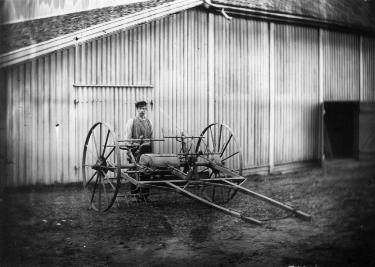 Fredrik Emil Faye, Hjulrive, Dal gård, Ullensaker. Gårdsarbeider bak hjulrive foran uthus. Fra serie fotografert av kammerherre Fredrik Emil Faye (1844-1903), gårdens eier.