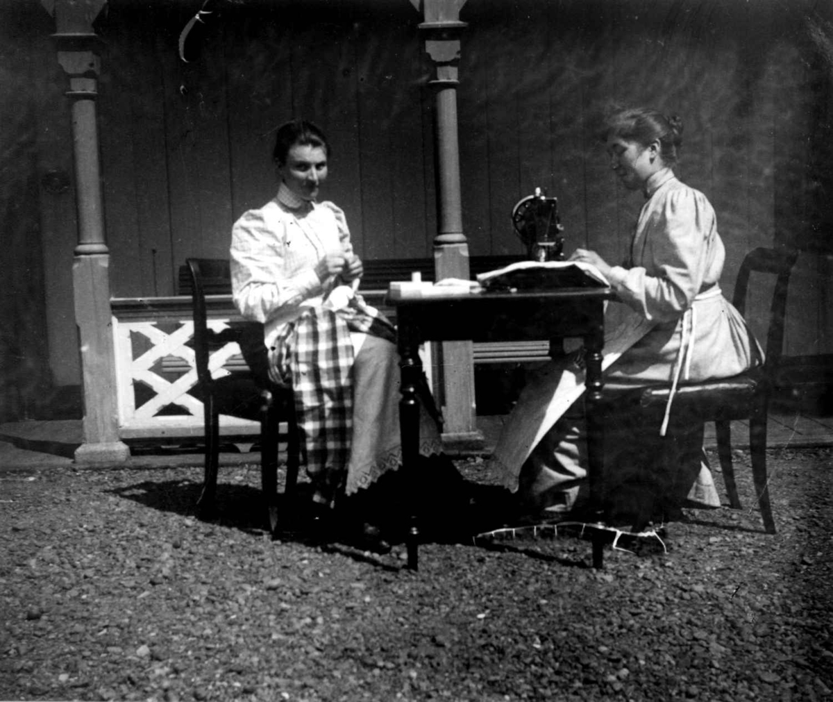 Fredrik Emil Faye, Sypiker, Dal gård, Ullensaker, ca. 1893. To kvinner med søm utendørs, den ene på symaskin. Fra portrettserie av personer som bodde på eller besøkte Dal gård, Ullensaker, fotografert av gårdens eier, kammerherre Fredrik Emil Faye (1844-1903) i årene 1875-1900.