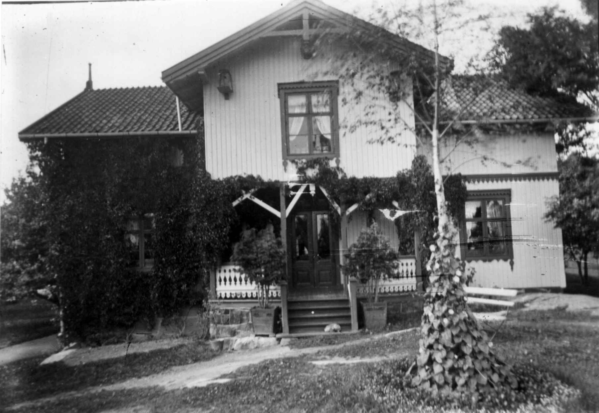 Hermann Christian Neupert, Hus med veranda, Norge. På drakt fot. av mange mennesker fot. ved dette hus.