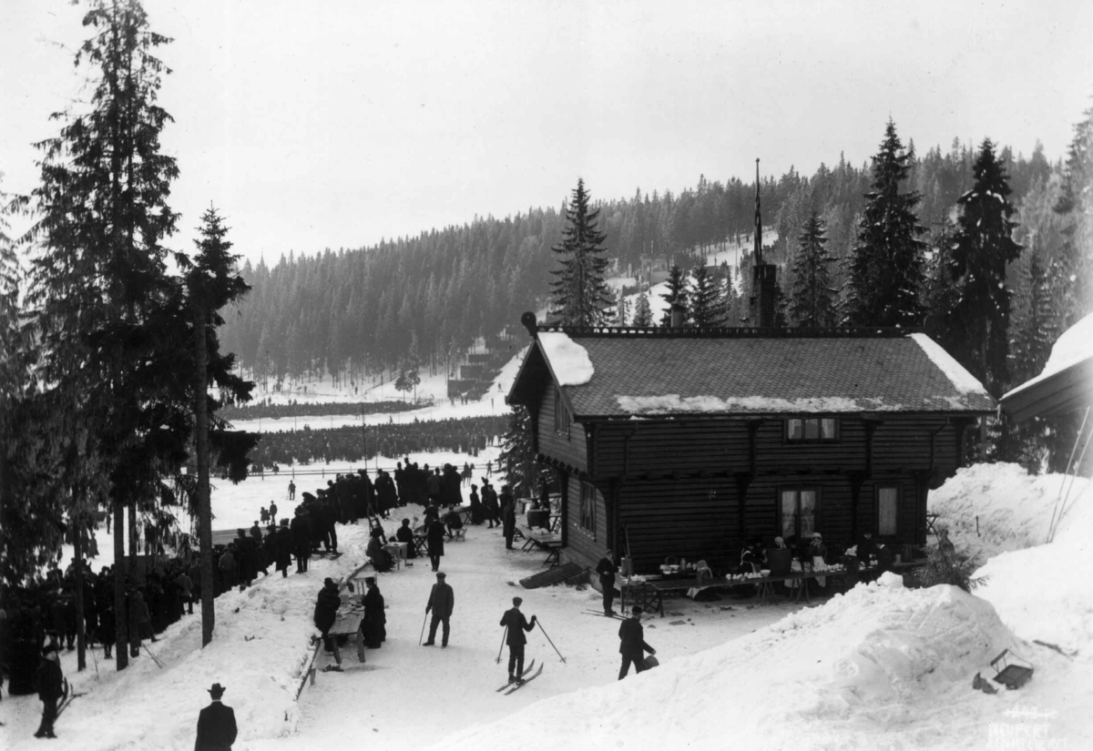 Hermann Christian Neupert, Fra Holmenkollrennet, Oslo. 1908 -1910. Vintermotiv. Hoppbakken. Tilskuere. I forgrunnen Skistua.