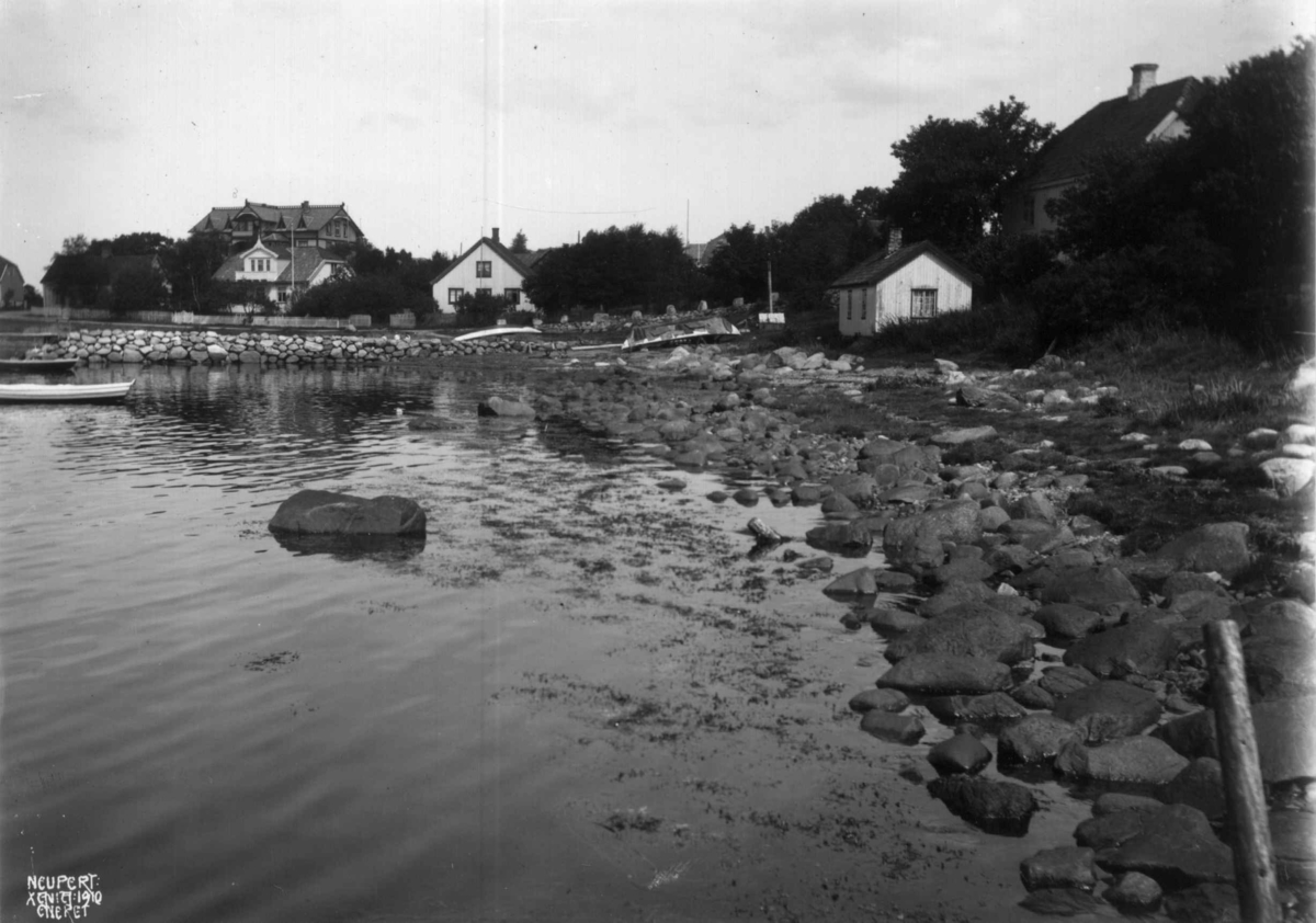 Hermann Christian Neupert, Larkollen, Rygge, Østfold 1910. Strandparti. Bebyggelse. Brygger med båter.