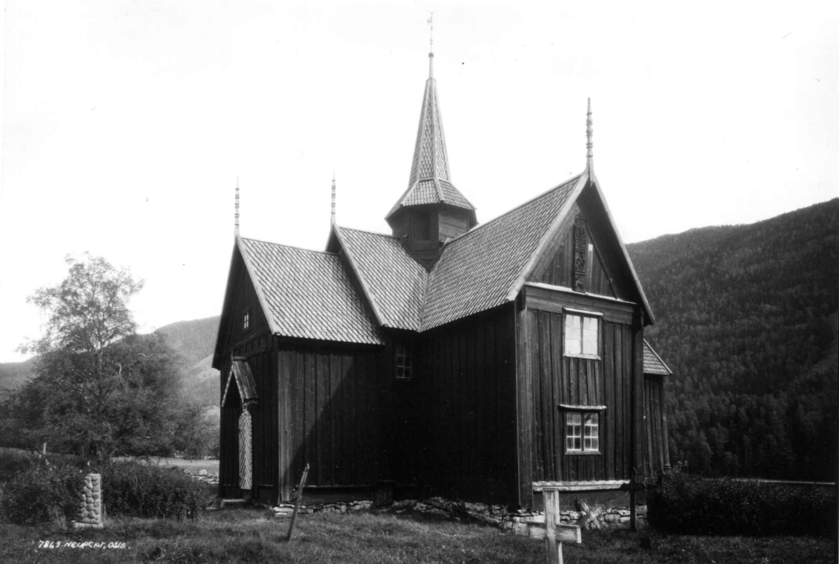 Hermann Christian Neupert, Nore stavkirke, Numedal, Buskerud. 1930. Kirkegård. Skog og åser i bakgrunnen.