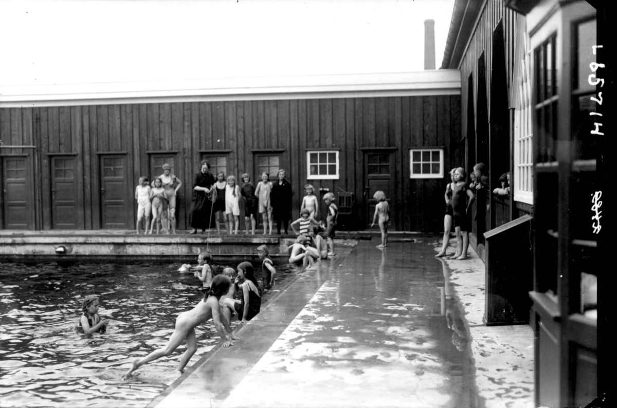 Hermann Christian Neupert, Personer i bassengkanten, badehus. Kvinner og barn i badedrakt. Noen barn uten badedrakter.