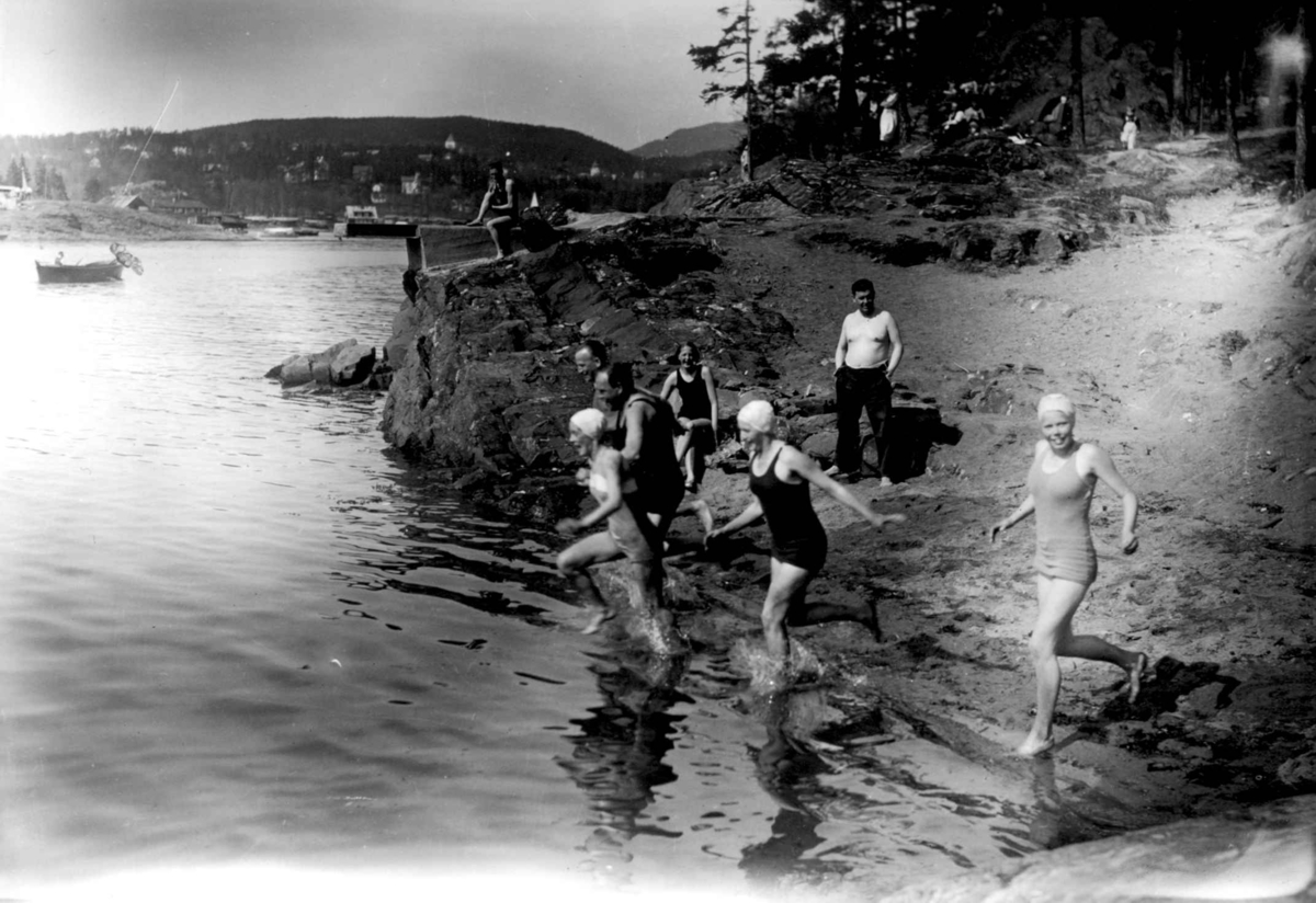 Hermann Christian Neupert, Badeliv. Ved Oslofjorden? Badende menn og kvinner. Svaberg. Bebyggelse i bakgrunnen.