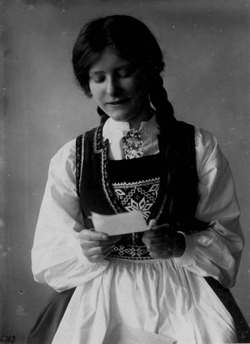 Hermann Christian Neupert, Kvinnedrakt fra Hardanger, Hordaland 1927. Kvinne med brev i hånden.