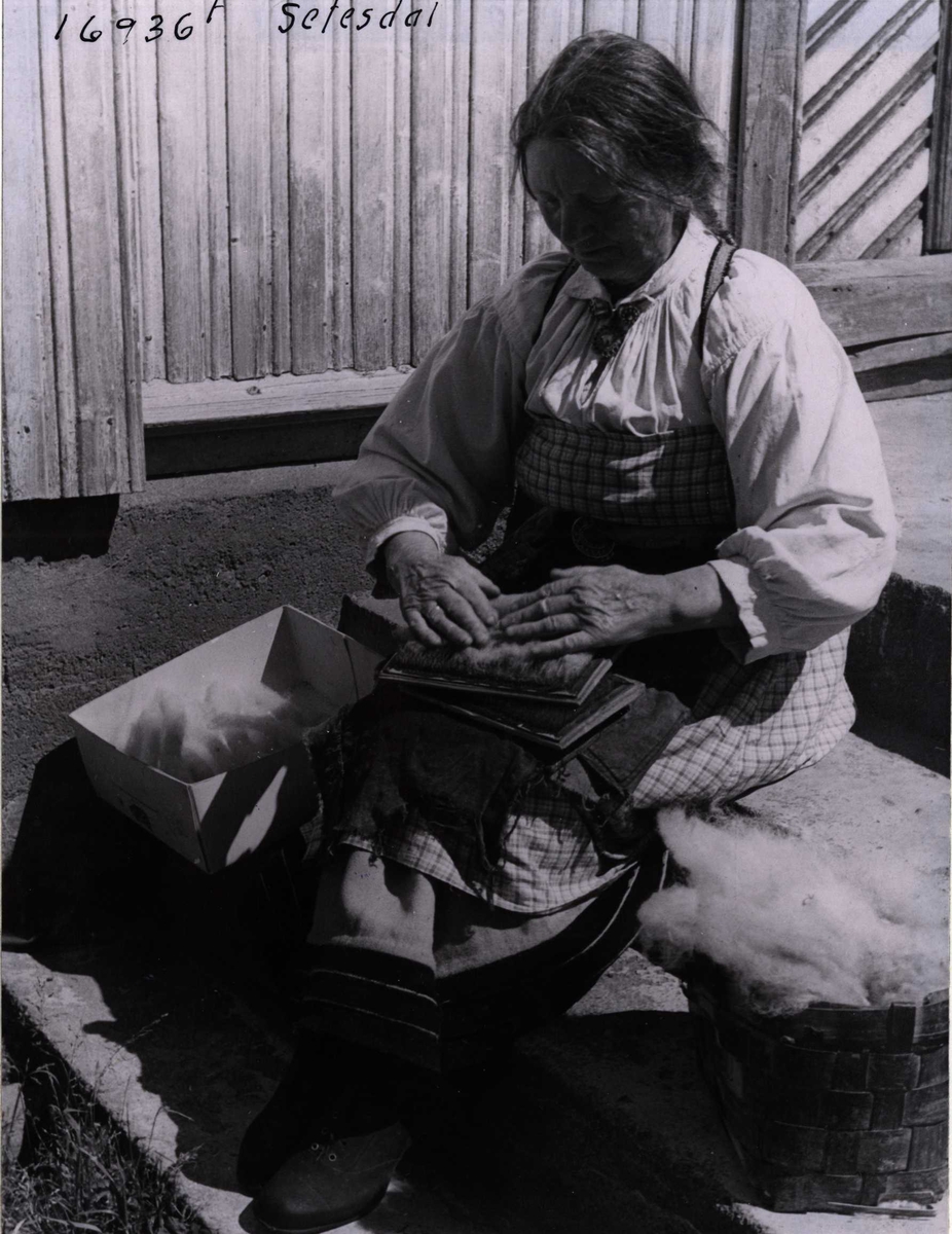 Anders Beer Wilse, En kvinne karder ull. Setesdal, Aust-Agder, 1943.