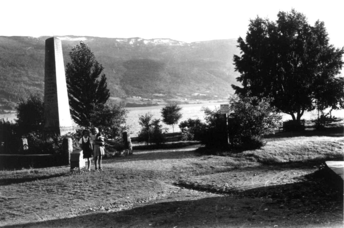 Hermann Christian Neupert, Voss 1939. Veteranbautaen omgitt av en liten park. To småjenter i forgrunnen. Vann, skog og fjell i bakgrunnen.