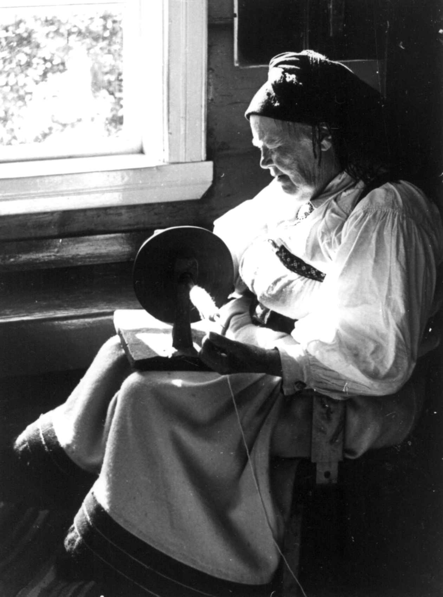 Anna Grostøl, Valle 1939. Portrett av Gunnhild Viki mens hun spoler garn på trespole.