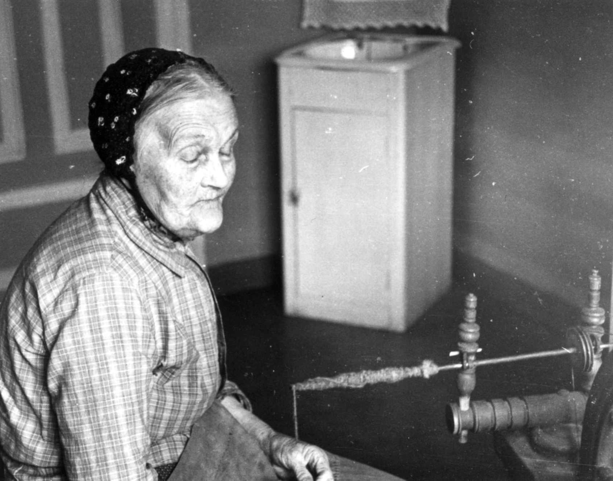 Anna Grostøl, Fru Ingeri Netland sitter ved en håndteinrokk, Fjotland, Kvinesdal, Vest-Agder 1939.