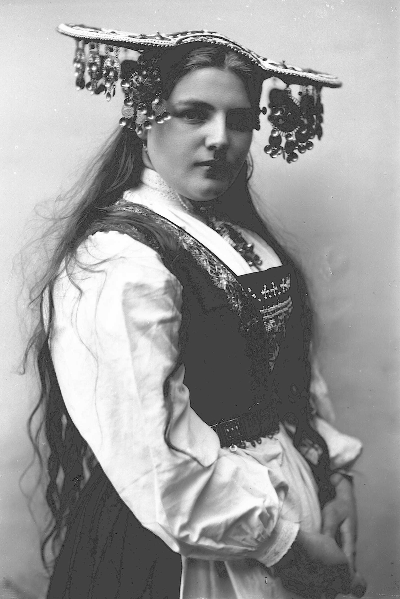Solveig Lund, Studiofotografi av kvinne med brudedrakt og brudehatt på hodet. Stående hofteutsnitt. Vendt mot høyre. Ser ut av bildet.