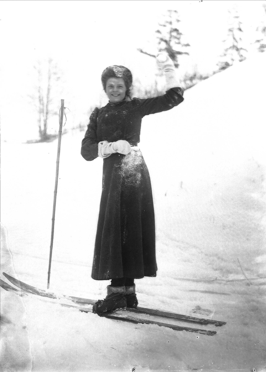 Solveig Lund, Kvinne i snødekt landskap. Kaster snøball med ski på beina.