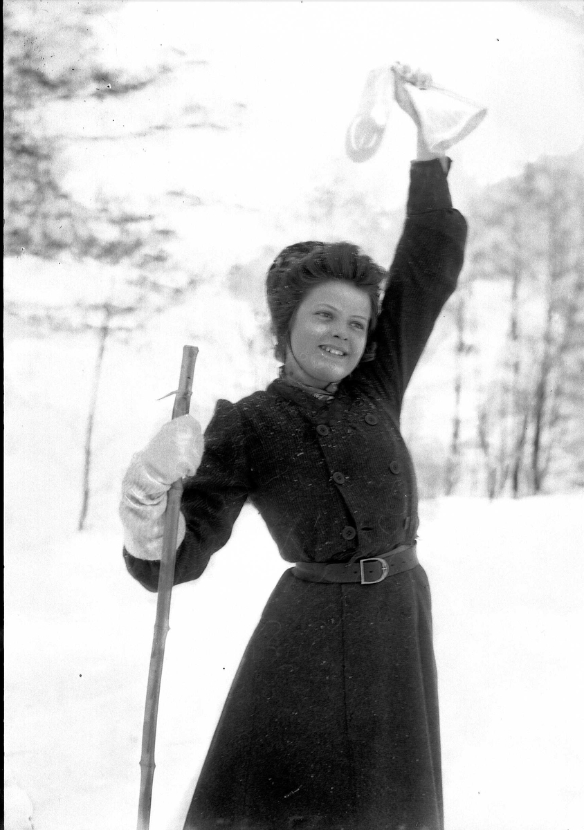 Solveig Lund, Kvinne i snødekt landskap. Hun har ski på beina og vinker med den ene votten.