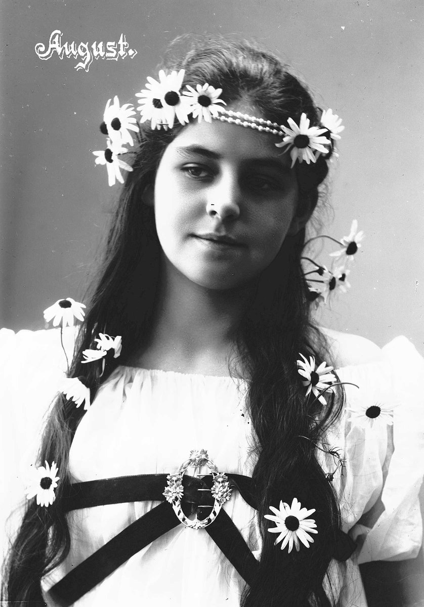 Solveig Lund, Studioportrett av kvinne i drakt med blomster og smykke i håret.