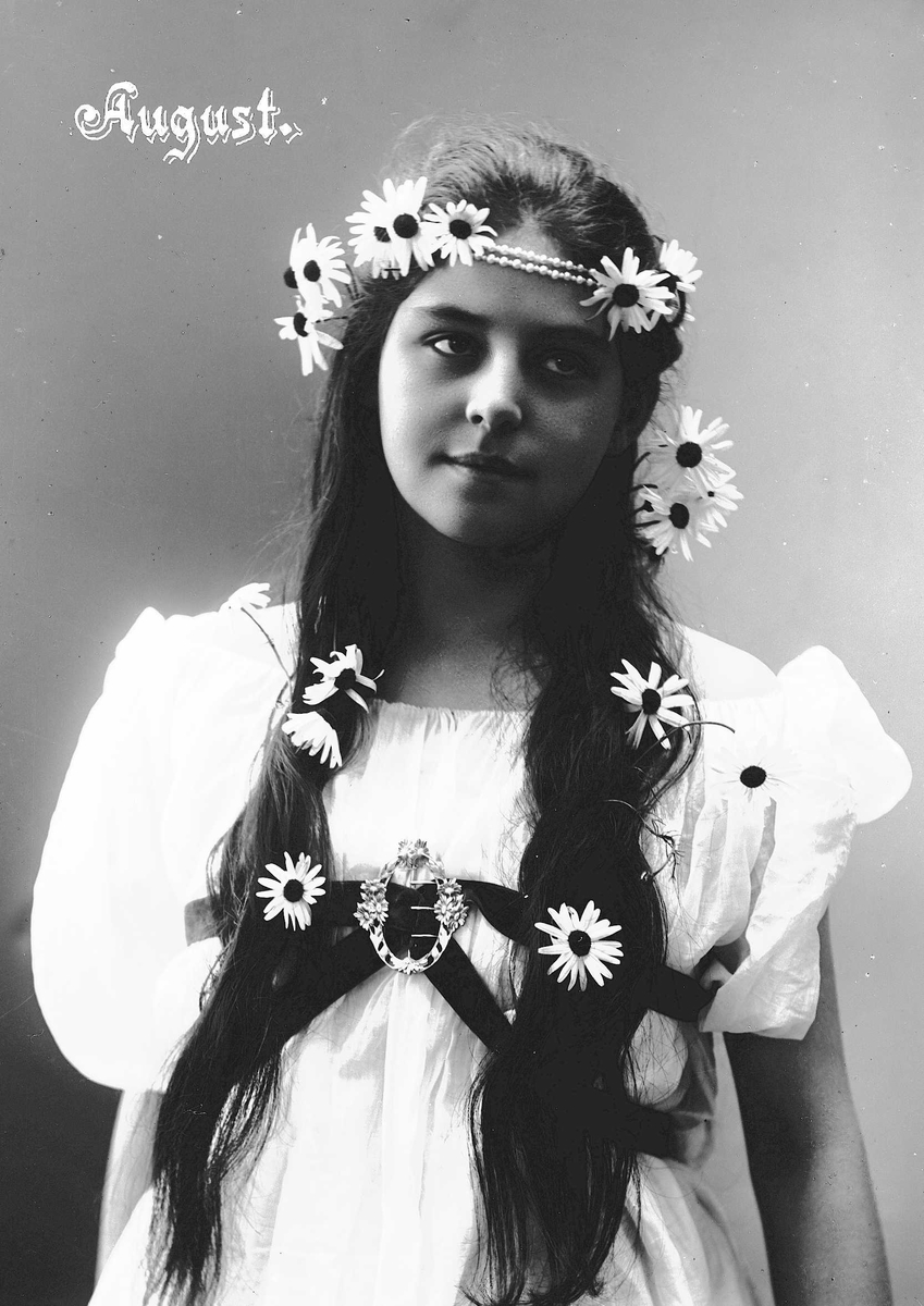 Solveig Lund, Studioportrett av kvinne i drakt med blomster og smykke i håret.