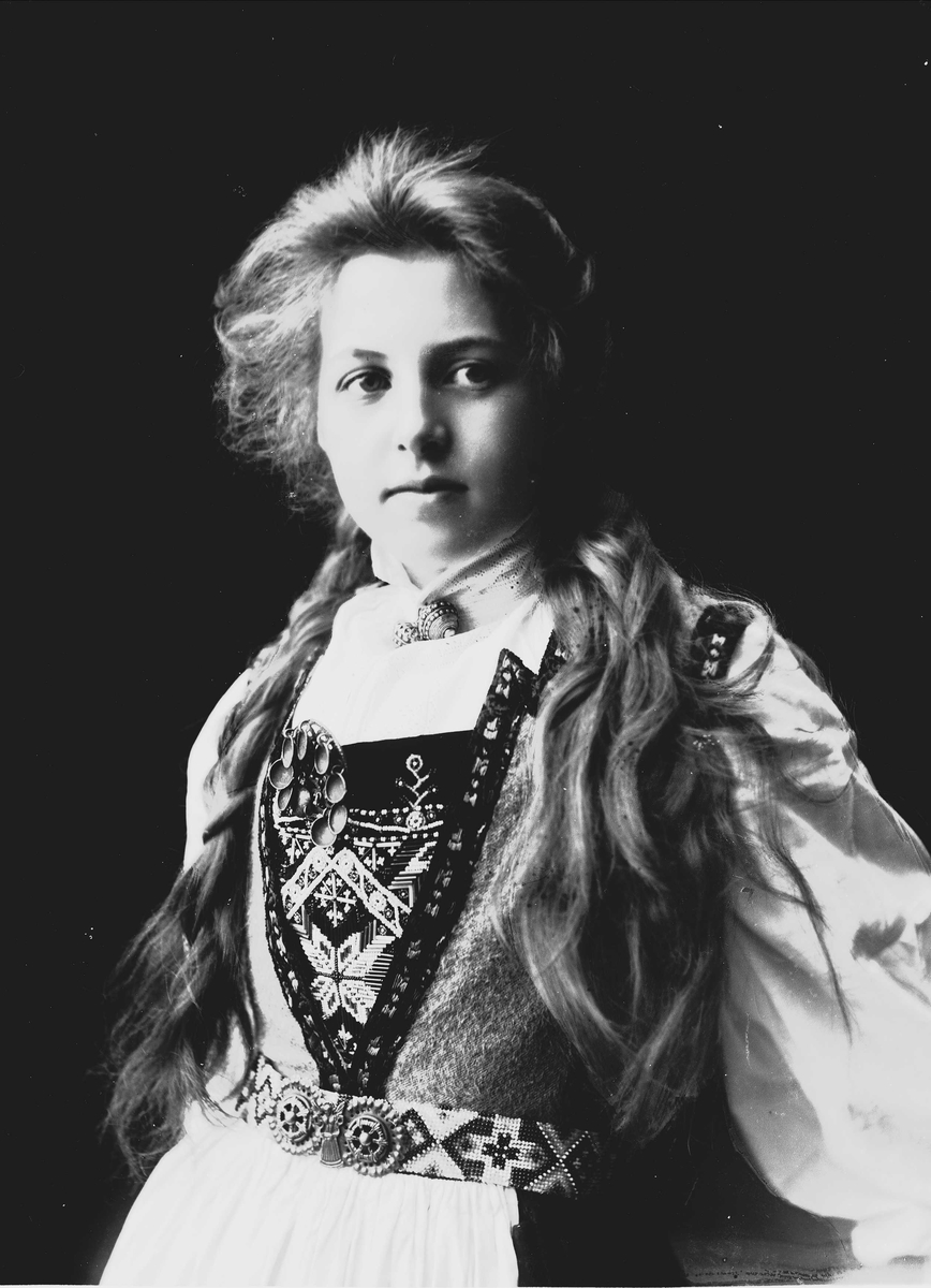 Solveig Lund, Studioportrett av kvinne i drakt med fletter.