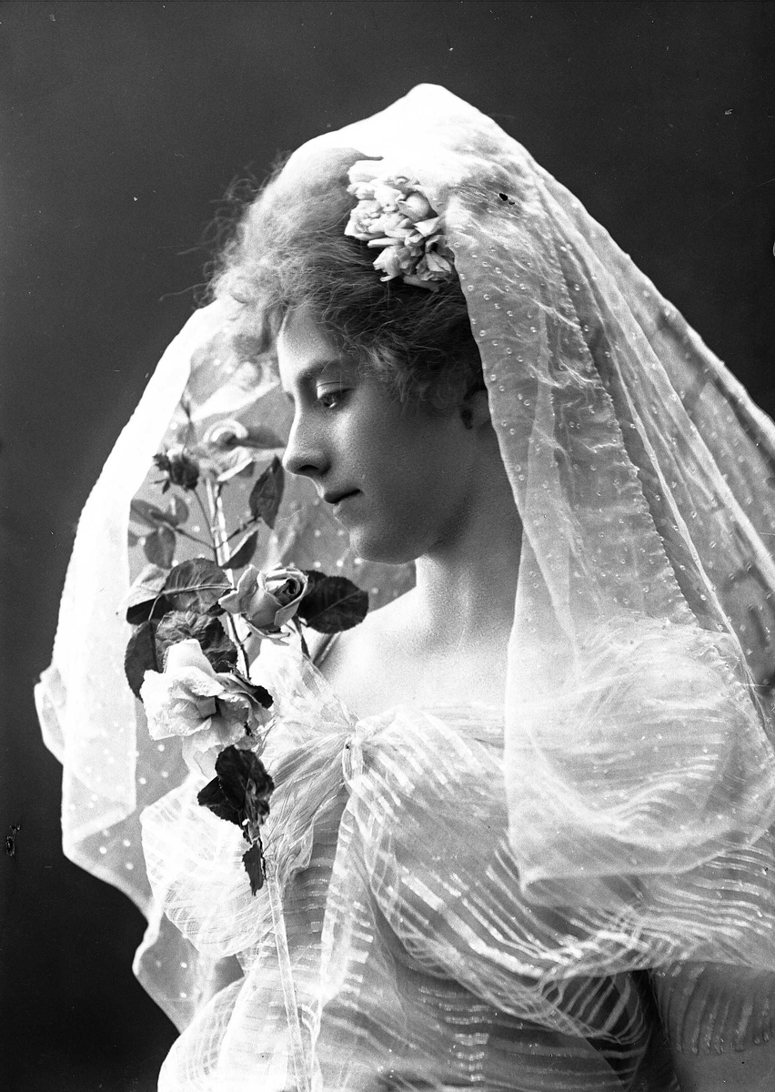 Solveig Lund, Studioportrett av kvinne i kostyme, oppsatt hår og slør - hvit overdel og blomster i håret.
