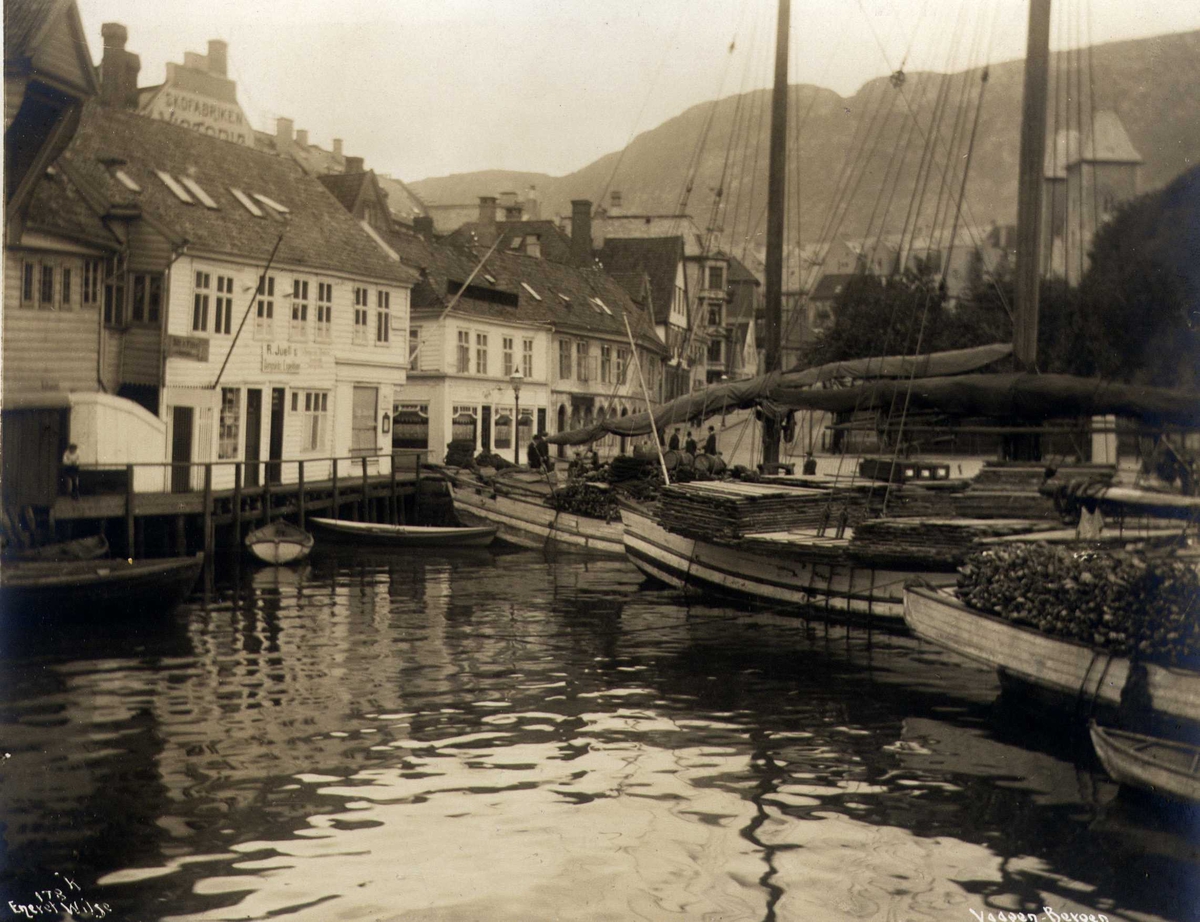 Anders Beer Wilse, Havneområde med fraktfartøy med last, jekter og trehusbebyggelse, Vågen, Bergen, Hordaland. Fotografert 1912.