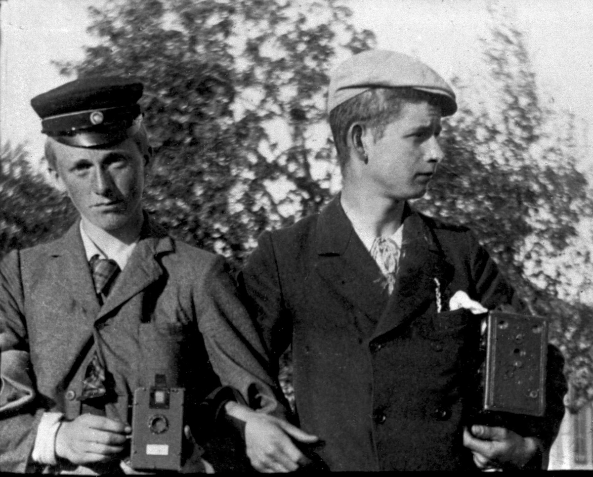 Gustav Borgen, To unge gutter arm i arm med hvert sitt fotografiapparat.