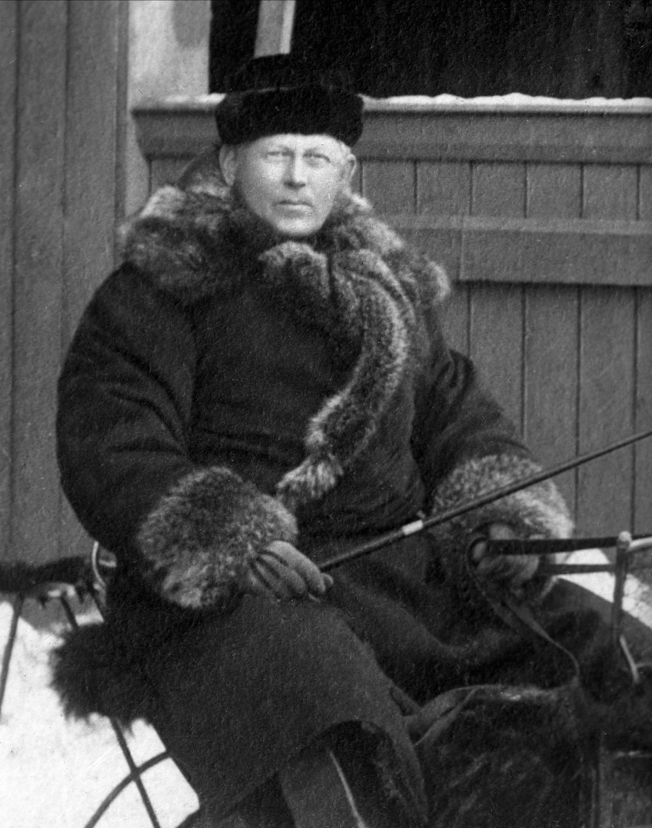 Gustav Borgen, Portrett, mann på sledesete, i kjøreklær med pisk i hånda.