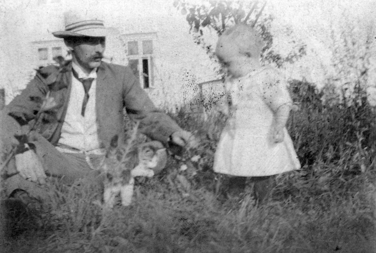 Ukjent, Trolldalen under Øvre Tomter (?) (60/1). Kan være Martin Larsen som var husmann i Trolldalen fra 1903. I hagen med barn.