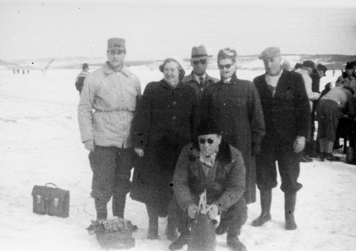 Ukjent, Pilkekonkurranse, Nordsveodden,Ottestad, Mjøsa, 1958. Mjøsfiske. Gruppe deltagere og tilskuere. F.v. Eivind Bakken, Signe Bakken, Alf Bakken, Bergljot Bakken, Mikkel Bakken. Foran Alf Falldalen. Arrangør var Ottestad IL.
