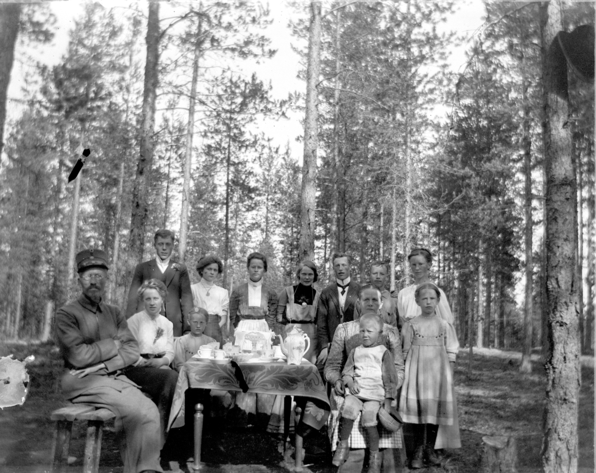 Johs. (Johannes) Johannessen, Et lite bryllupsselskap. Fra venstre trolig brudens far, så brudgom stående og bruden sittende - begge med blomster i knapphullet, Stående bak nr 2 er Anna Marie Johannessen og en tjenestepike. Bord, kaffeservise.