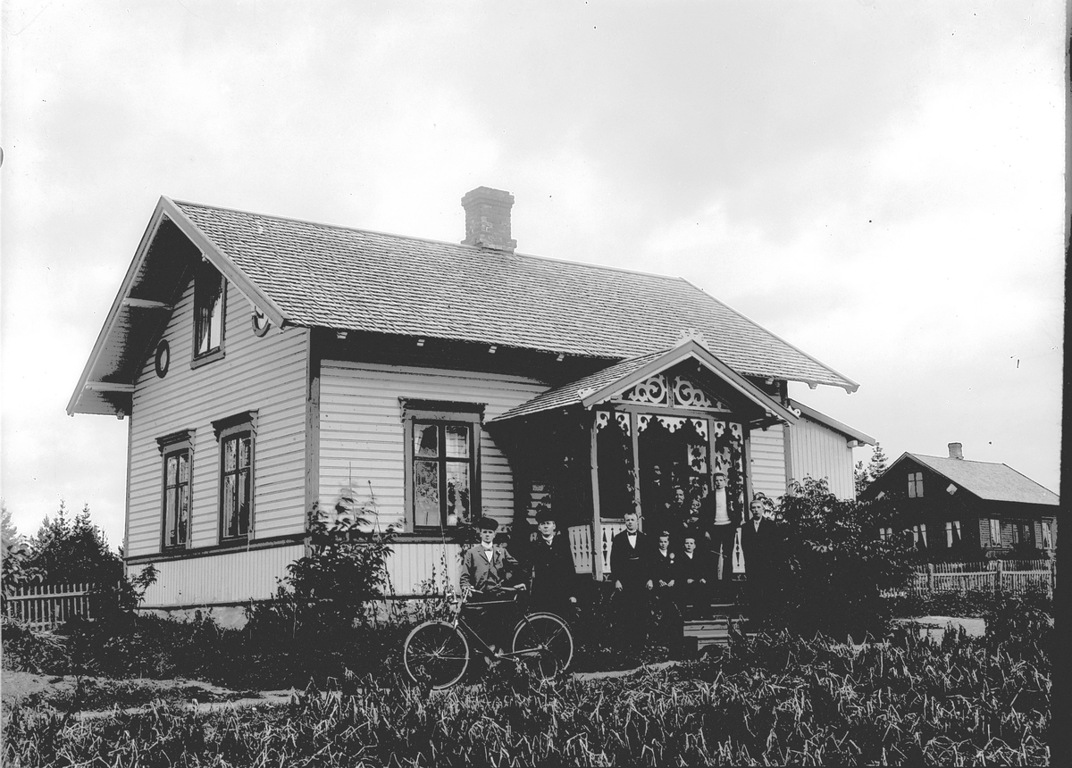 Ragnvald Andersen, Stor gruppe på trappa til et hus. En mann holder en sykkel.