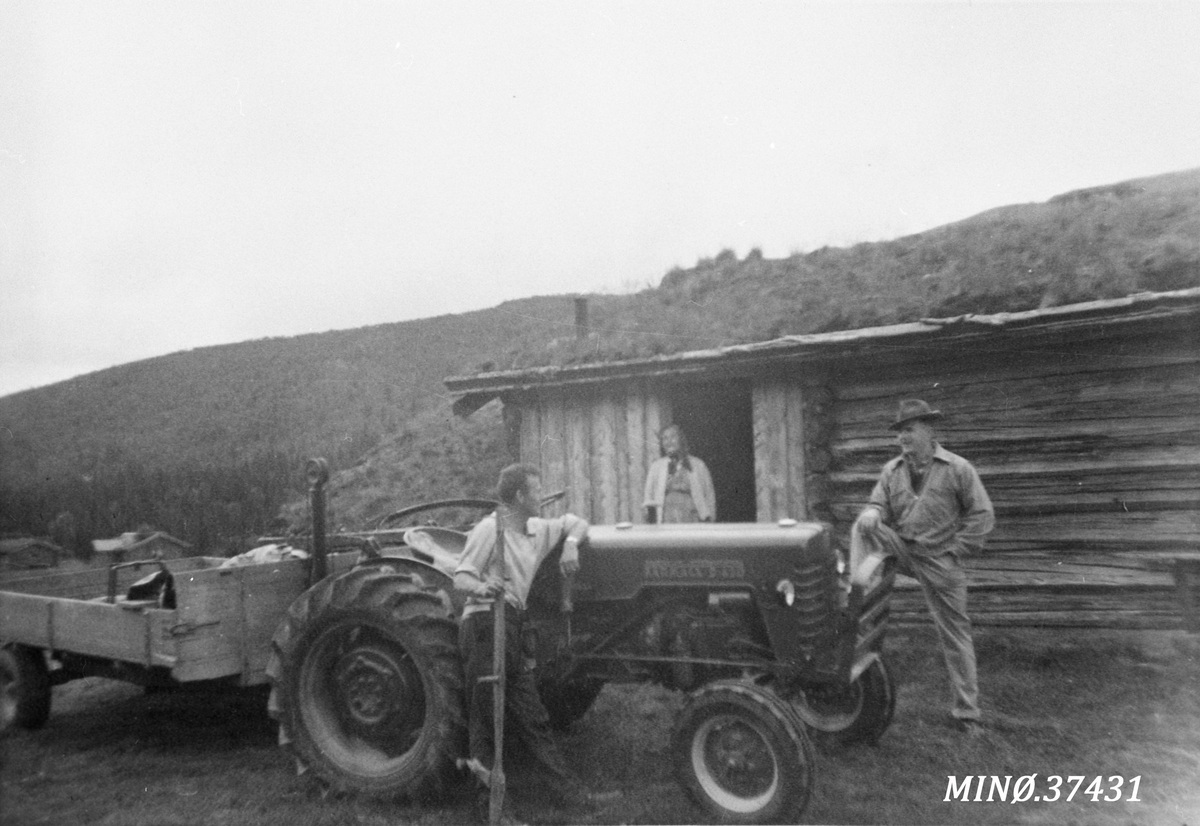Ukjent, Mann,traktor og tilhenger, mann med ljå, kvinne i døråpningen