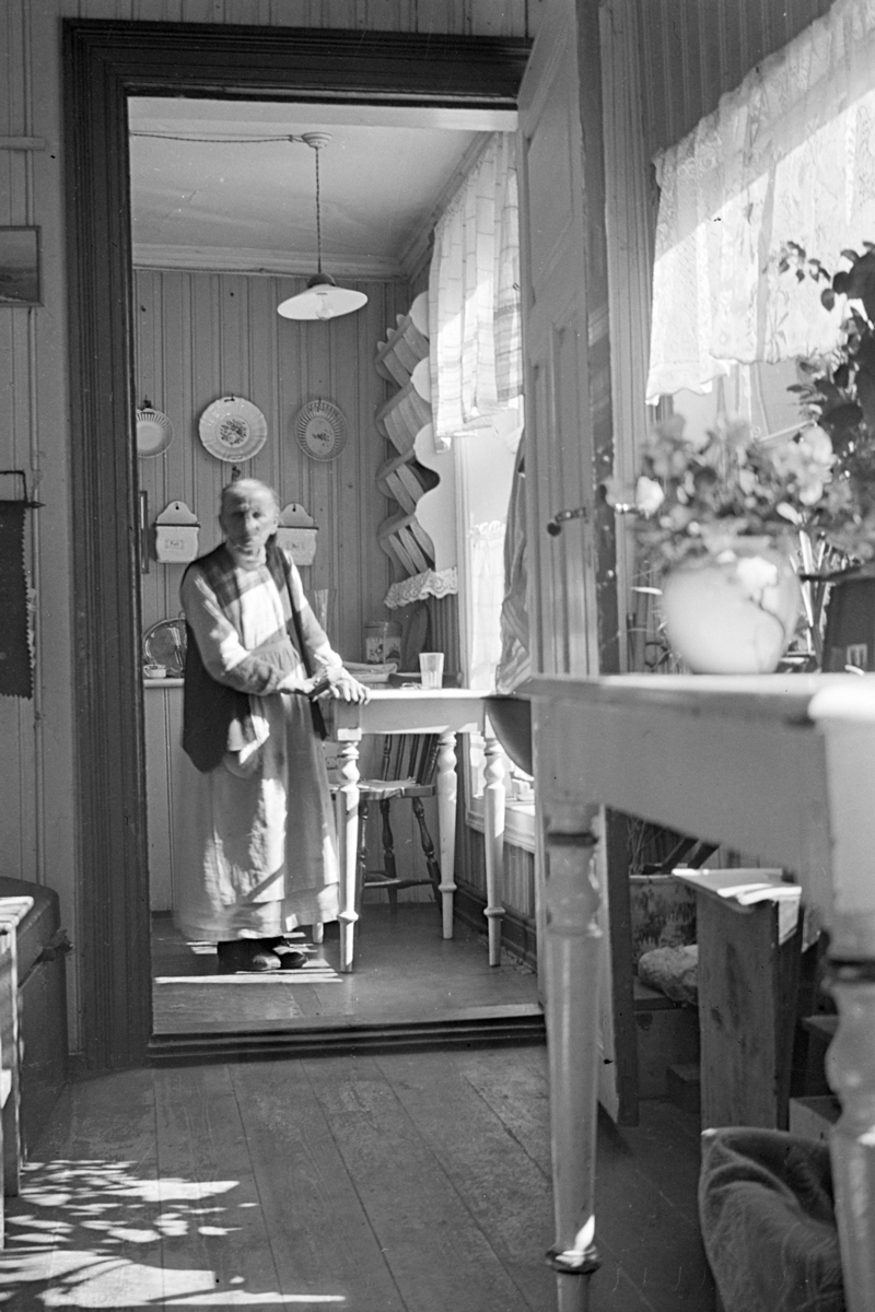 Johs. (Johannes) Johannessen, Interiør, eldre ukjente kvinne på kjøkken.