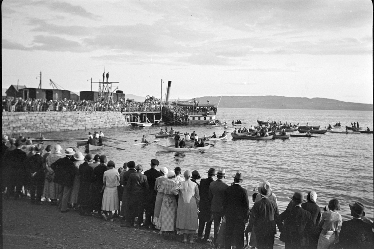 Johs. (Johannes) Johannessen, Jernbanebrygga, Hamar. Stor folkemengde, robåter, mjøsbåt, Mjøsa. Konkurranse.