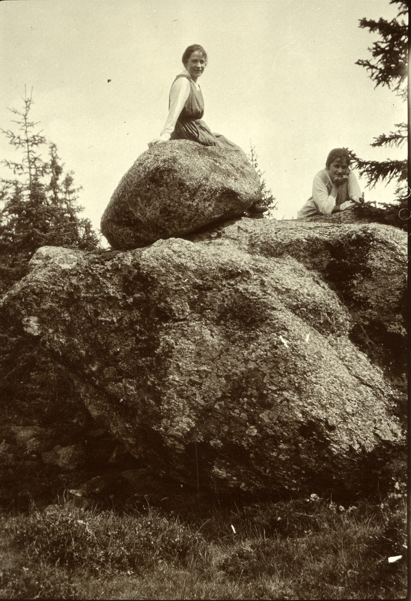 Haakon Garaasen, To kvinner på en kjempestor stein i Galåsen. Sittende (øverst) Olga Petrine Galaasen (s) g. Lundgren (8/10 1887) (død i Oslo). Liggende (til høyre) Gjerterud Mathilde Galaasen (s) g. Stenersen (7/6 1890 - 1966)
