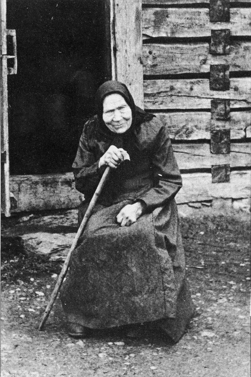 Rachel Haarseth, Eldre kvinne, klær, spaserstokk, bygning.