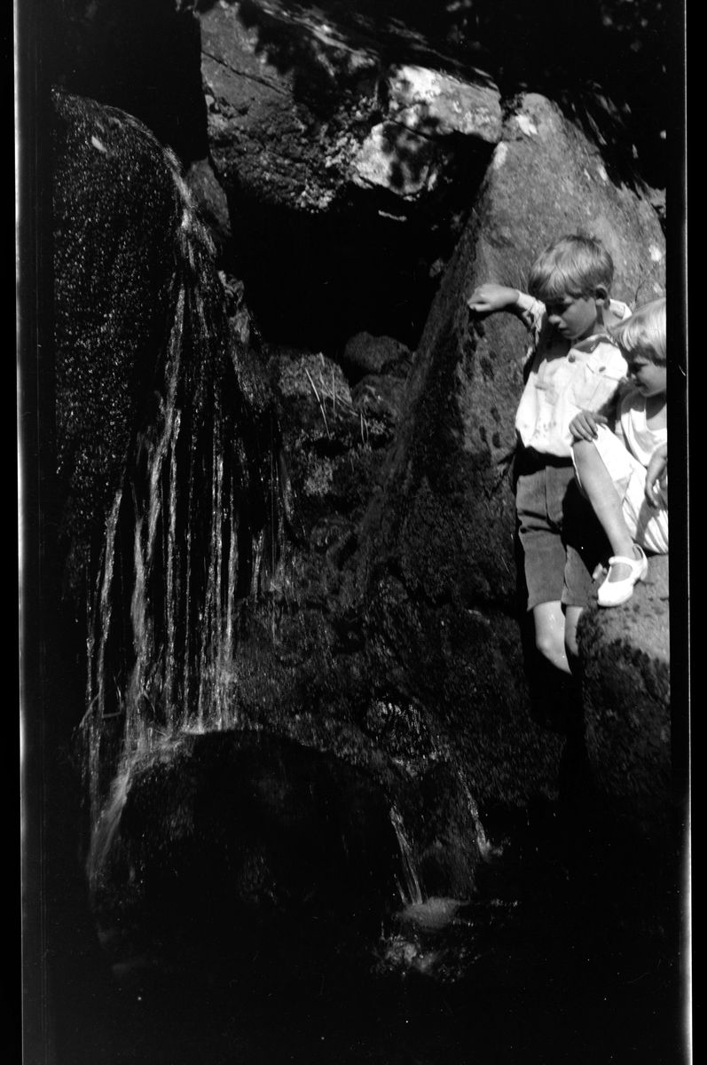 Rolf Sr. Sundt, Rolf Sundt jr. og Eva Guhnfeldt ser på vannfall i et naturlandskap med fjell.